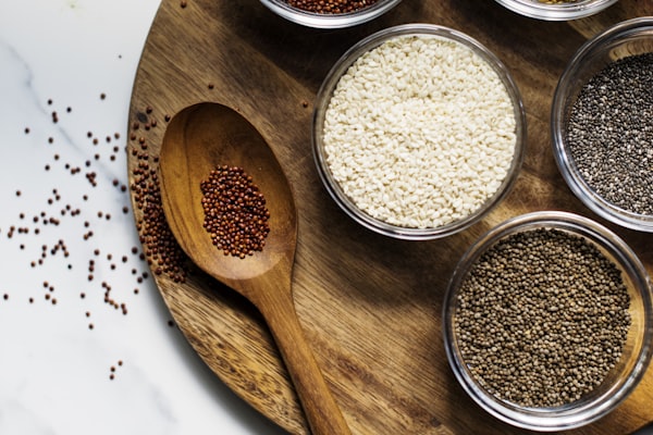 Variety of seeds in glass bowls on a wooden board